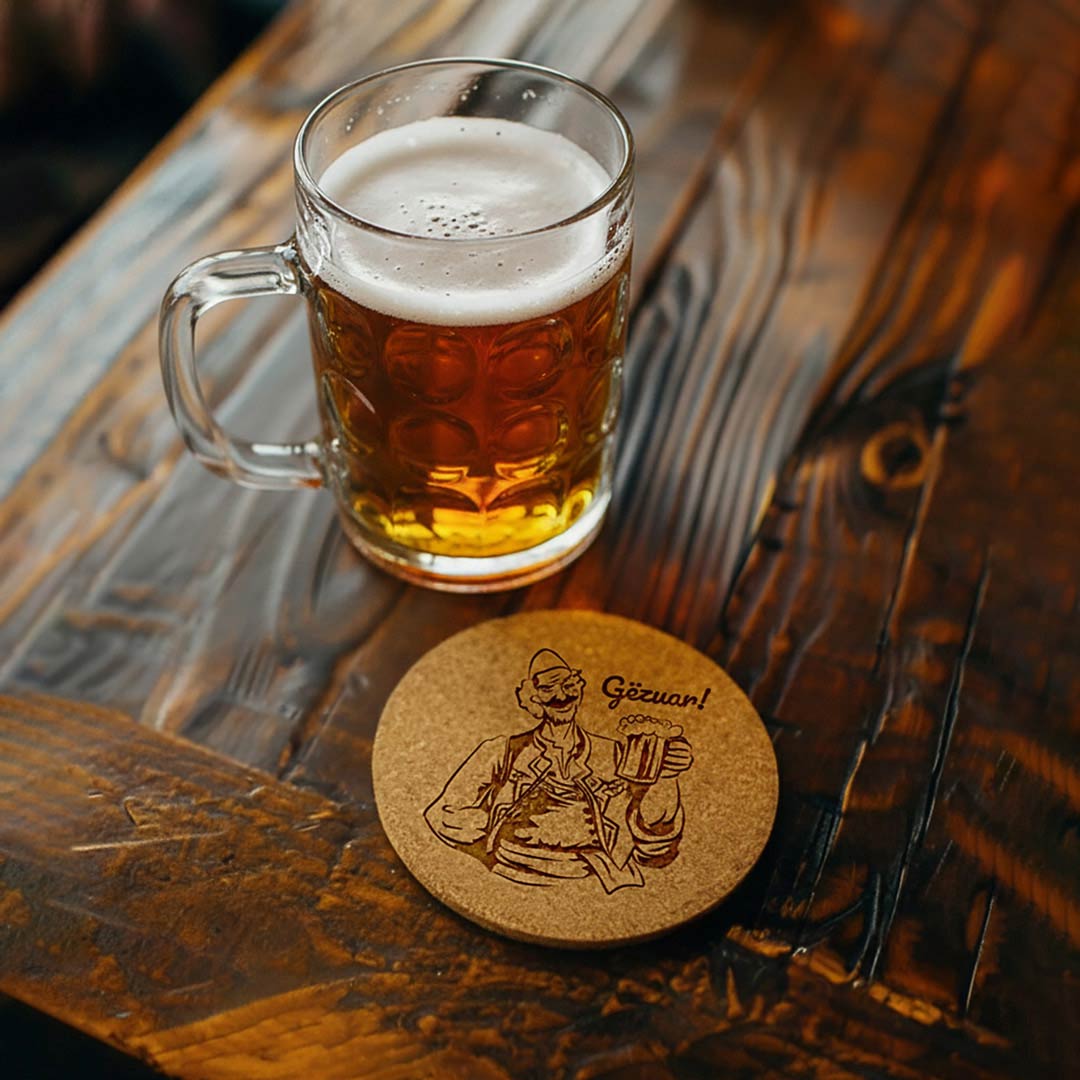 Burrë shqiptar me plis dhe me birrë në dorë, me "Gëzuar" gdhendur në tapë druri, set me 4 mbajtëse gotash, prodhuar në Shqipëri - symbol.al
Albanian man with a Plis and a beer, with "Gëzuar" (Cheers), engraved in set of 4 cork coasters, souvenir made in Albania - symbol.al